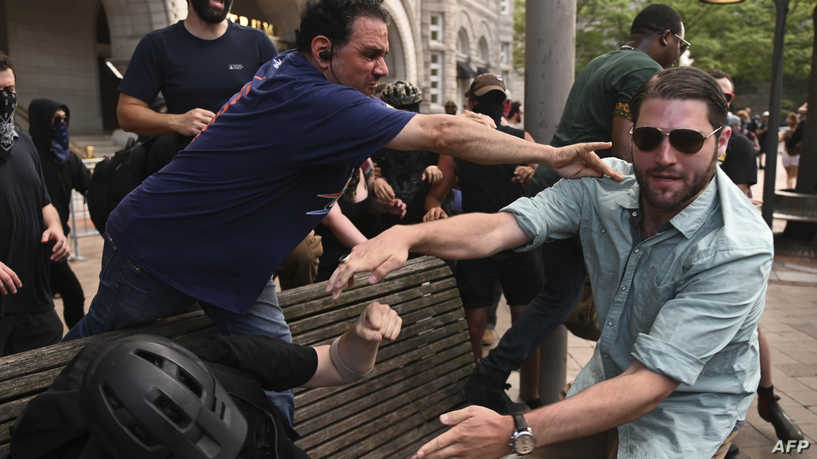 A member of the far right (R) grabs an anti-fascist or Antifa member on a bench after a "Demand Free Speech" rally in Washington, DC, on July 6, 2019. (Photo by ANDREW CABALLERO-REYNOLDS / AFP)