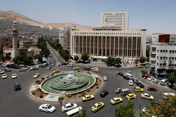 Vehicles drive along the roundabout past the Central bank of Syria in the capital Damascus' Sabaa Bahrat Square on June 17, 2020. (Photo by LOUAI BESHARA / AFP)