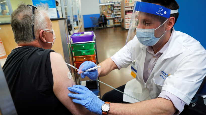 Walmart pharmacist Carmine Pascarella administers a Moderna coronavirus disease (COVID-19) vaccine for local resident Geoff Corakhill inside a Walmart department store as Walmart and other major U.S. pharmacies take part in the Federal Retail Pharmacy Program, to increase vaccinations in the U.S. in West Haven, Connecticut, U.S., February 17, 2021. REUTERS/Mike Segar