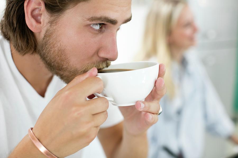 young-man-drinking-coffee-from-cup-science-photo-library