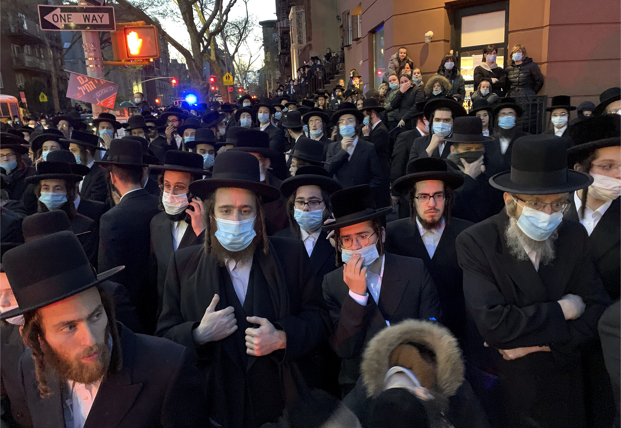 Hundreds of mourners gather in the Brooklyn borough of New York, Tuesday, April 28, 2020, to observe a funeral for Rabbi Chaim Mertz, a Hasidic Orthodox leader whose death was reportedly tied to the coronavirus. The stress of the coronavirus' toll on New York City's Orthodox Jews was brought to the fore on Wednesday after Mayor Bill de Blasio chastised "the Jewish community" following the breakup of the large funeral that flouted public health orders.(Peter Gerber via AP)