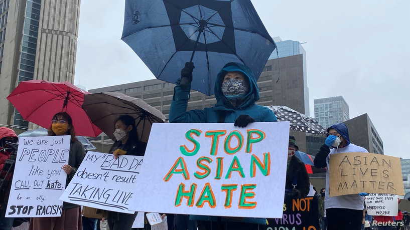 People hold placards as they gather to protest against anti-Asian hate crimes, racism and vandalism, outside City Hall in Toronto, Ontario, Canada, March 28, 2021. REUTERS/Kyaw Soe Oo