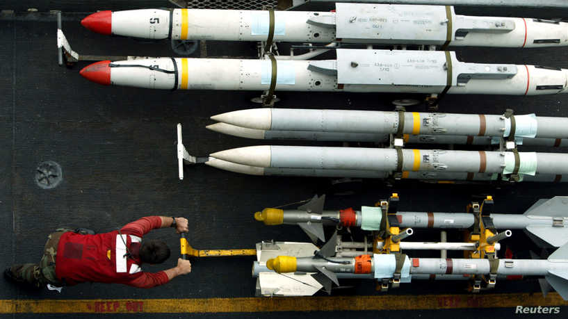 An aviation ordinanceman wheels AIM-9 sidewinder air-to-air missiles into place alongside AIM-120 AMRAAM air-to-air intercept missiles (C) and AGM-88 HARM air-to-ground missiles on the flight deck of the USS Kitty Hawk in the northern Persian Gulf March 10, 2003. U.S. and British navies are more worried about al Qaeda strikes on ships in the event of war with Iraq than anything [Saddam Hussein] could throw at them, the deputy allied sea commander said on Monday.