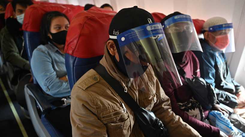 Passengers wearing face shields and face masks wait prior to take off on a Lion Air flight bound for Palembang, at the Sukarno-Hatta airport in Tangerang on June 26, 2020. (Photo by ADEK BERRY / AFP)