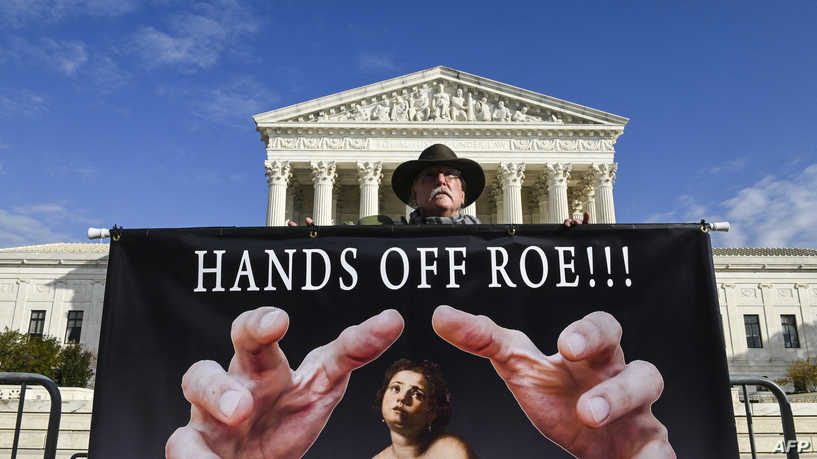A man holds a sign supporting Roe vs. Wade in front of the US Supreme Court Building in Washington, DC on November 30, 2021. - The Supreme Court will hear arguments in a case concerning Mississippi's 15-week abortion ban, potentially paving the way for abortion rights in the U.S. to be severely restricted as the case could result in Roe v. Wade being significantly weakened or overturned. (Photo by ROBERTO SCHMIDT / AFP)