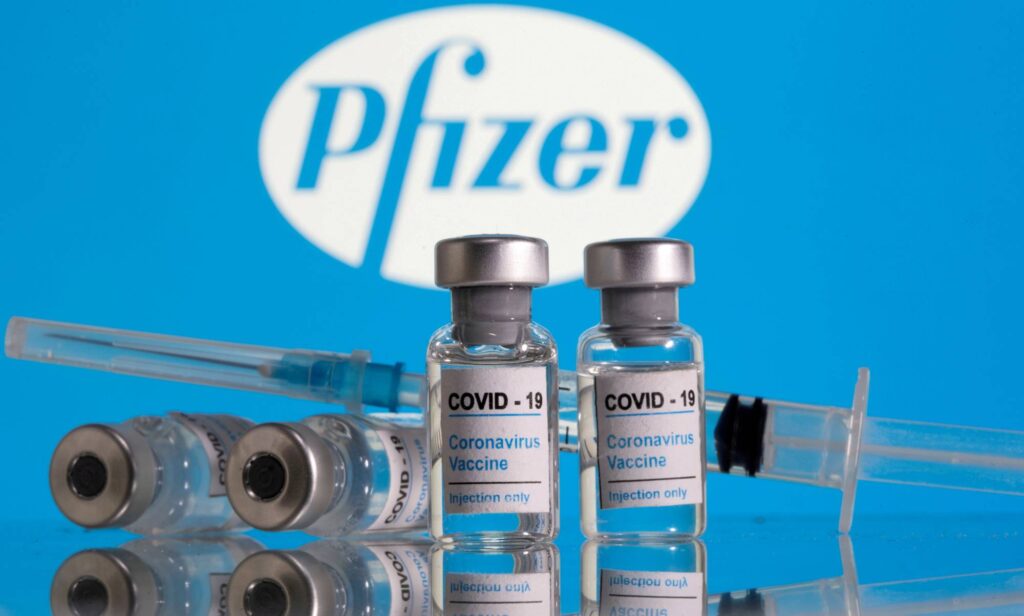 FILE PHOTO: Vials labelled "COVID-19 Coronavirus Vaccine" and a syringe are seen in front of the Pfizer logo in this illustration taken February 9, 2021. REUTERS/Dado Ruvic/Illustration/File Photo