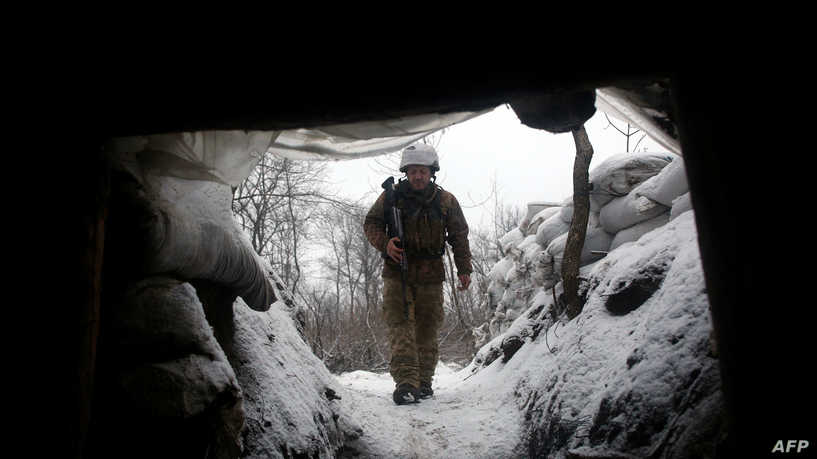 An Ukrainian Military Forces serviceman walks along a snow covered trench on the frontline with the Russia-backed separatists near Zolote village, in the eastern Lugansk region, on January 21, 2022. - Ukraine's Foreign Minister Dmytro Kuleba on January 22, 2022, slammed Germany for its refusal to supply weapons to Kyiv, urging Berlin to stop "undermining unity" and "encouraging Vladimir Putin" amid fears of a Russian invasion. (Photo by Anatolii STEPANOV / AFP)