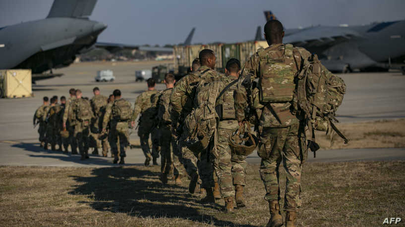 US soldiers line up to board a plane from Pope Army Airfield in Fort Bragg, North Carolina on February 14, 2021. - US service members based in Fort Bragg, North Carolina, are preparing deploy to Europe as the crisis between Russia and Ukraine escalates. (Photo by Allison Joyce / AFP)