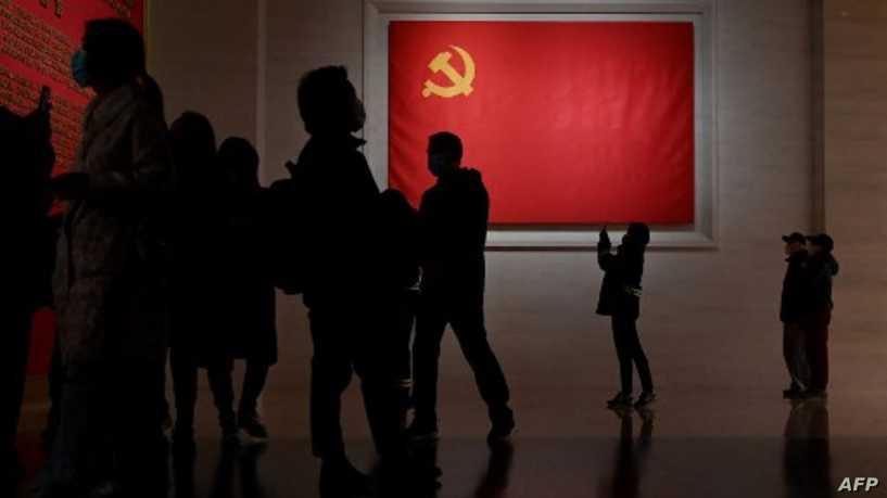 Visitors walk in front of the national flag on display at the Museum of the Communist Party of China in Beijing on November 11, 2021. (Photo by Noel Celis / AFP)