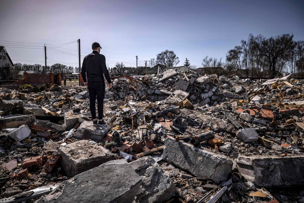 A plainclothes policeman stands  among the rubble of destroyed houses in Bohdanivka village, northeast of Kyiv, on April 14, 2022, amid Russia's invasion launched on Ukraine. (Photo by FADEL SENNA / AFP) (Photo by FADEL SENNA/AFP via Getty Images)