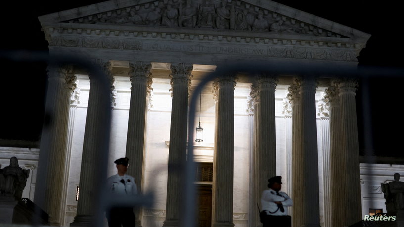 Security personnel stand guard outside the U.S. Supreme Court as protesters react after the leak of a draft majority opinion written by Justice Samuel Alito preparing for a majority of the court to overturn the landmark Roe v. Wade abortion rights decision later this year, in Washington, U.S., May 2, 2022. REUTERS/Jonathan Ernst