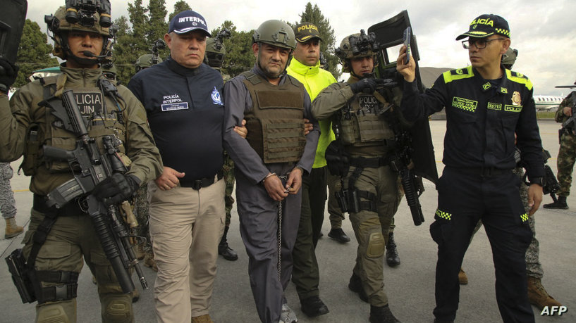 Members of the Colombian national police escort Colombian drug lord and head of the Gulf Clan, Dairo Antonio Usuga -aka 'Otoniel', as he is extradited to the US, in Bogota on May 4, 2022. - One of Colombia's most notorious drug lords was extradited Wednesday to the United States to face drug trafficking charges, said President Ivan Duque. (Photo by Colombian Presidency / AFP) / RESTRICTED TO EDITORIAL USE-MANDATORY CREDIT - AFP PHOTO / COLOMBIAN PRESIDENCY - NO MAFRKETING - NO ADVERTISING CAMPAIGNS - DISTRIBUTED AS A SERVICE TO CLIENTS